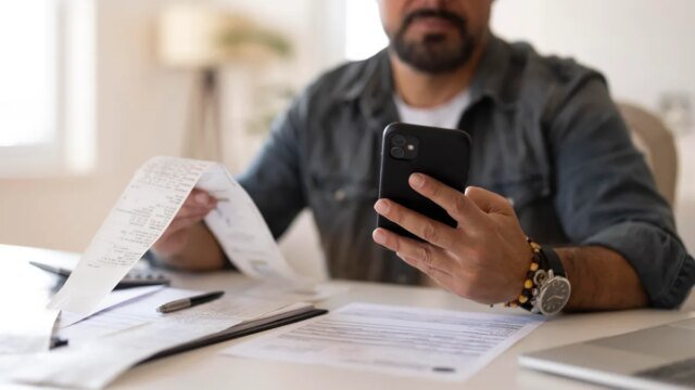 person-paying-bills-receipts-gettyimages-2252535730.jpg